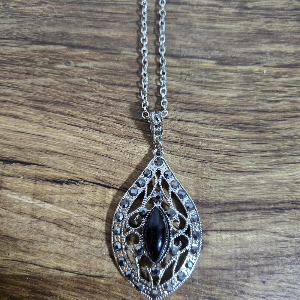vintage-style pendant necklace featuring a black onyx gemstone set in an ornate